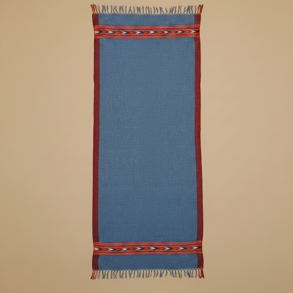 Blue woven rug with red border and fringe on a beige background