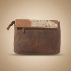 Brown leather pouch with cowhide pattern on a beige background