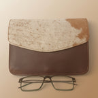 Brown leather case with a beige cloth and glasses on a white background