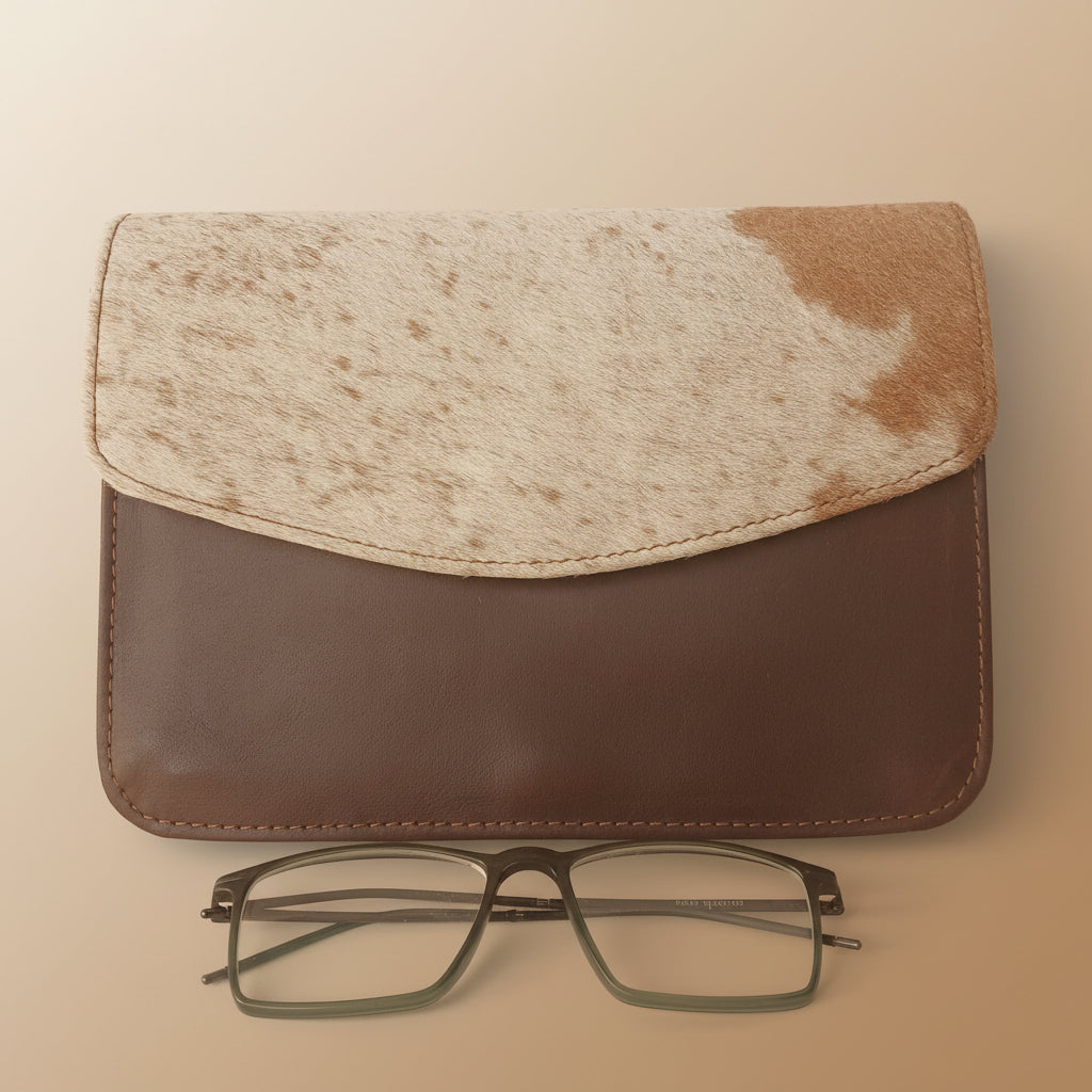 Brown leather case with a beige cloth and glasses on a white background