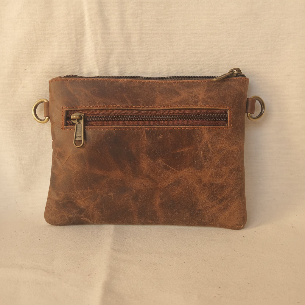 Brown leather pouch with zipper on a light gray background