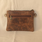 Brown leather pouch with zipper on a light gray background