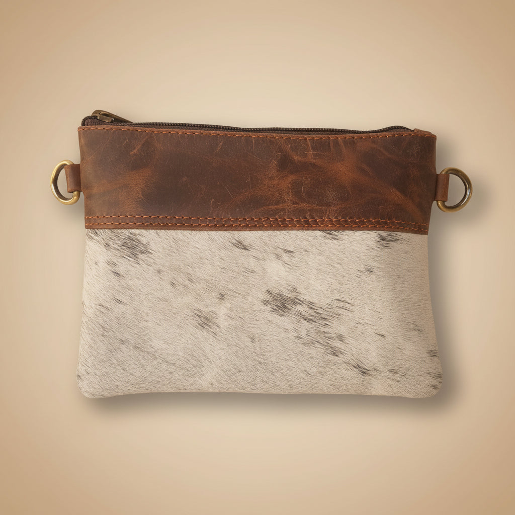 Brown leather pouch with gold ring on a textured white surface