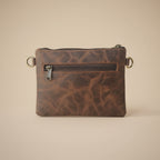 Brown leather pouch with zipper on a light gray background