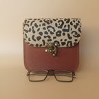Red wallet with leopard print coin purse and glasses on a white background