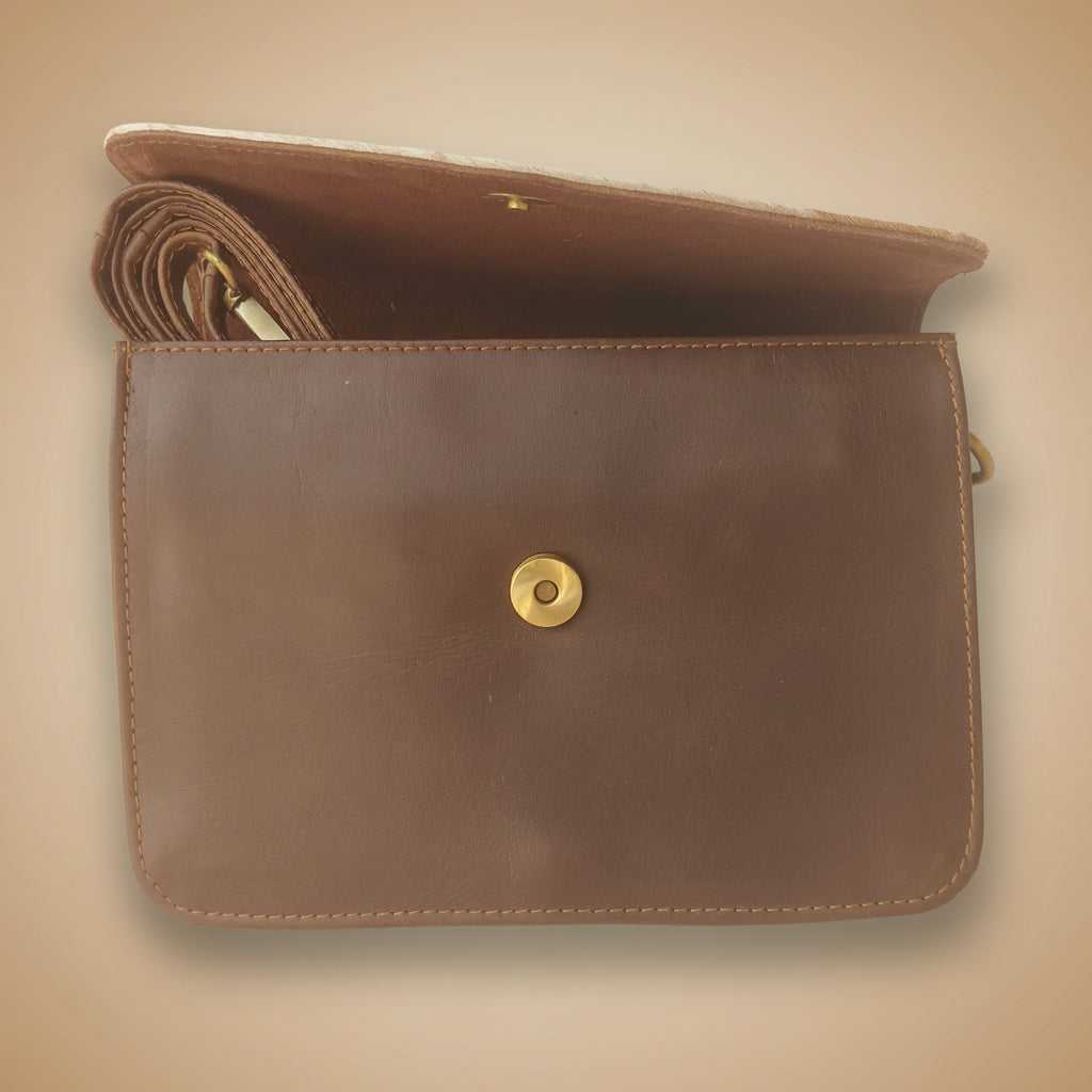 Brown leather clutch bag with a gold button on a white background