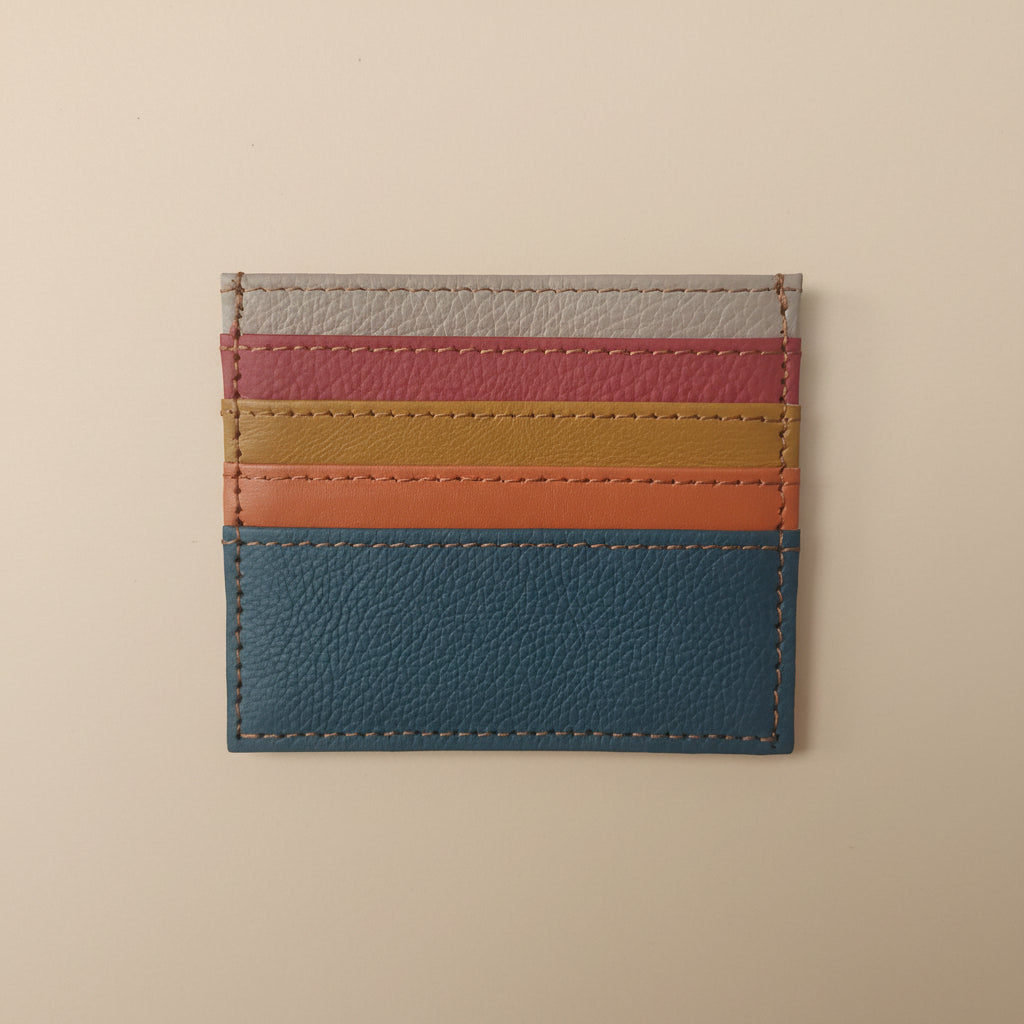 Multicolored striped leather cardholder on a light gray background