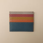 Multicolored striped leather cardholder on a light gray background