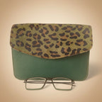 Leopard print case and green textured case with glasses on a white background