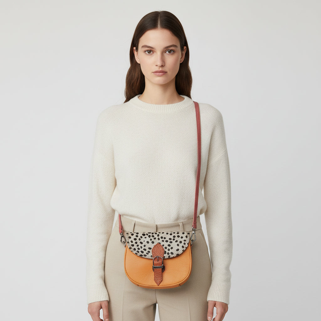 Small orange bag with a patterned flap on a light gray background