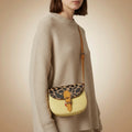 Leather handbag with leopard print top flap on a beige background