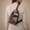 Person wearing a brown leather backpack with cowhide pattern on a beige background