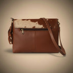 Brown leather clutch with cowhide pattern on a white surface
