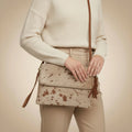 Brown cowhide leather clutch bag with fringe on a beige background