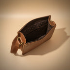 Brown leather bag with gold buckle on a beige background