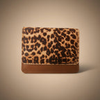 Leopard print wallet with brown base on a black background