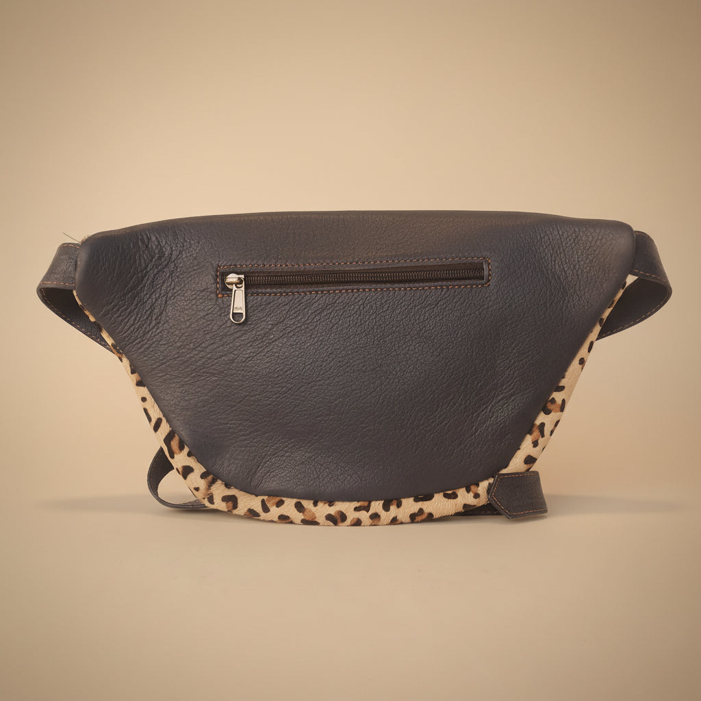 Blue leather bag with leopard print strap on a light gray background