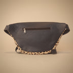 Blue leather bag with leopard print strap on a light gray background