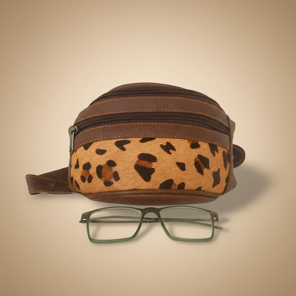 Round brown pouch with leopard print strap and glasses on a white background