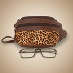 Brown bag with leopard print strap and glasses on a white background