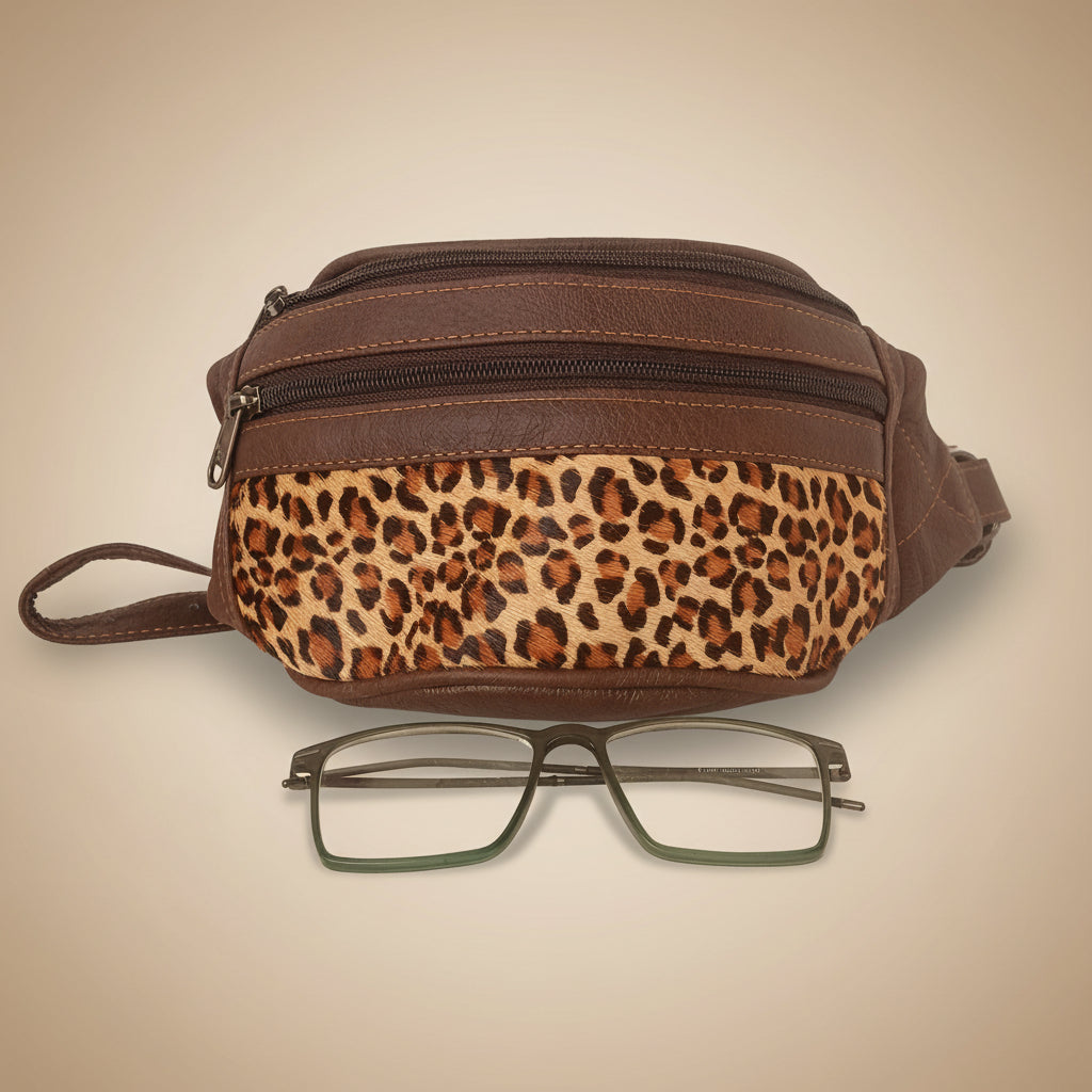 Brown bag with leopard print strap and glasses on a white background
