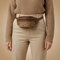 Brown bag with leopard print section on a beige background