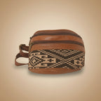 Brown leather bag with patterned strap on a white background