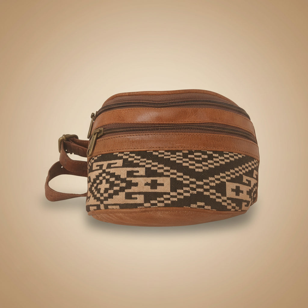 Brown leather bag with patterned strap on a white background