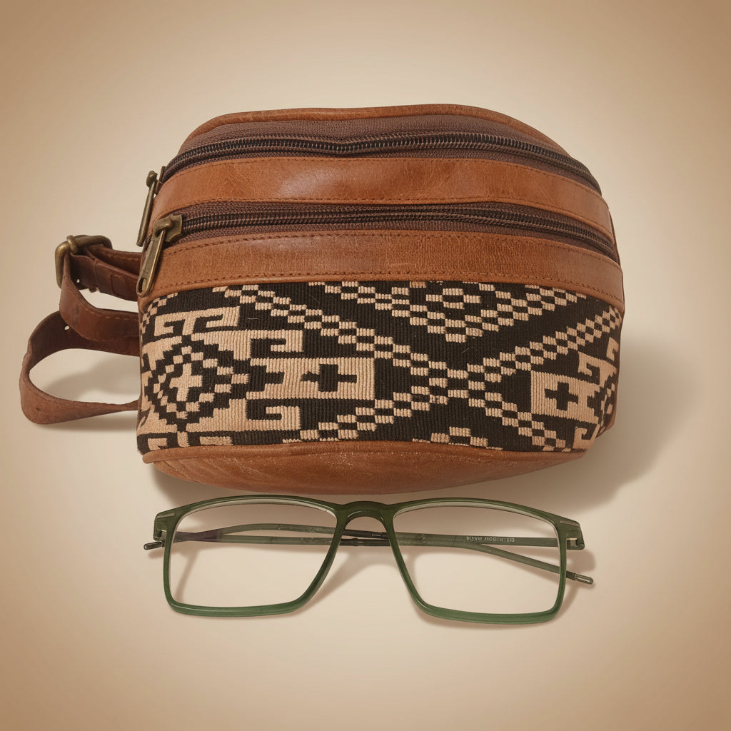 Brown patterned bag with a pair of glasses on a white background