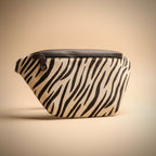 Zebra-patterned fanny pack on a beige background