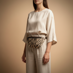 Woman wearing a zebra print belt bag against a beige background