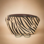 Zebra patterned pouch with a pair of glasses on a light gray background