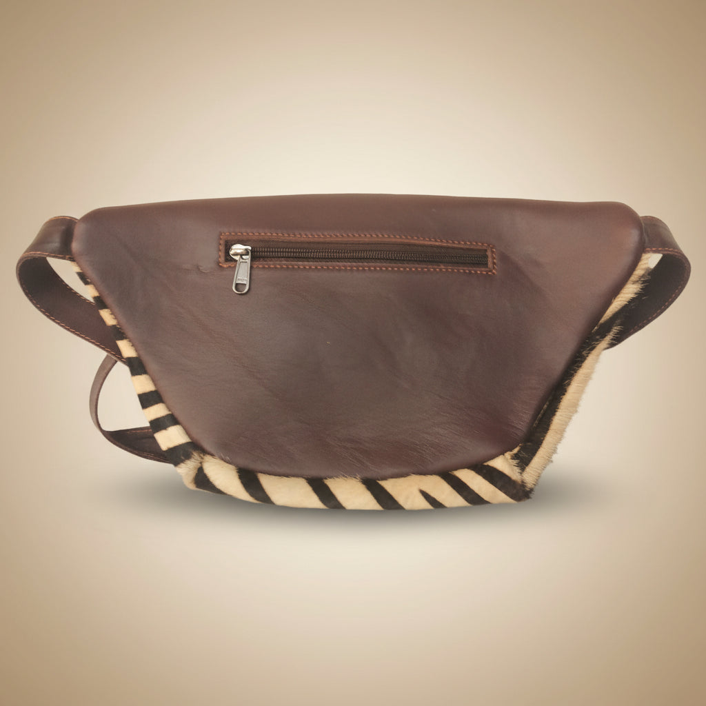 Brown leather bag with zippers on a light gray background