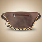 Brown leather bag with zippers on a light gray background