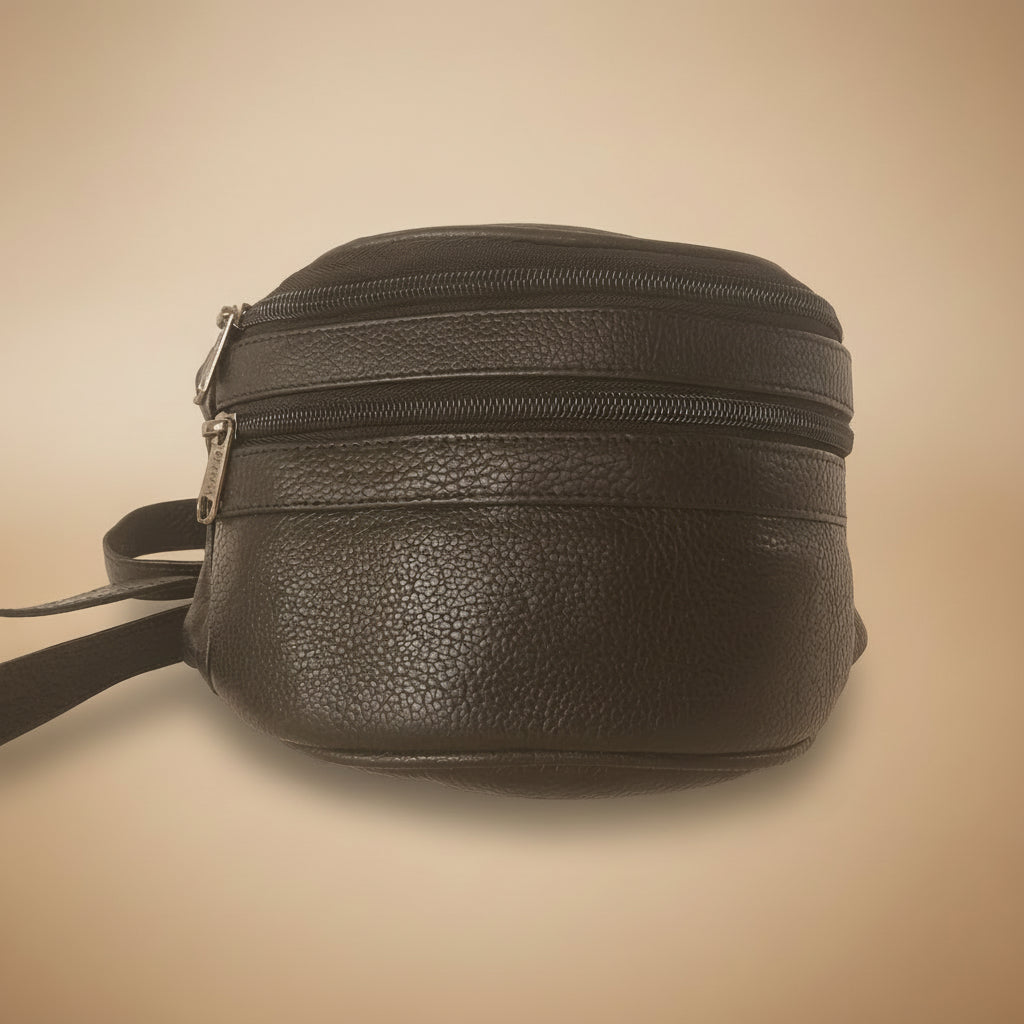 Black leather bag with a strap on a beige background