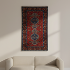Decorative rug with intricate patterns on a wall above a sofa