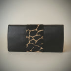 Black leather wallet with giraffe pattern strap on a light gray background