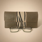 Gray eyeglass case with zebra pattern and glasses on a white background