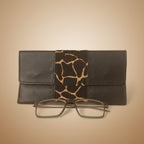Black leather wallet with giraffe pattern and glasses on a white background