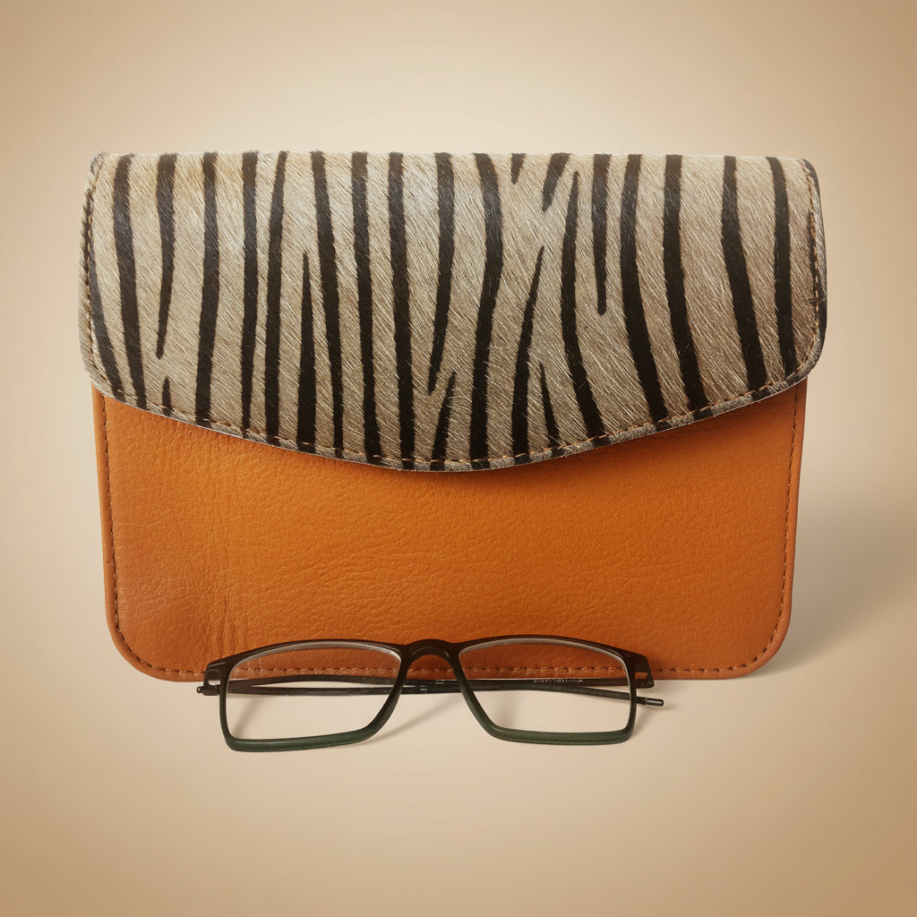 Eyeglasses in a zebra-patterned and brown case on a white background