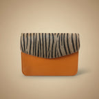 Phone case with zebra pattern on one side and brown leather on the other, on a light background