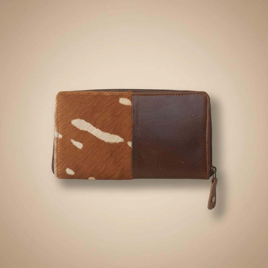 Brown leather wallet with cowhide pattern on a white background