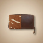 Brown leather wallet with cowhide pattern on a white background