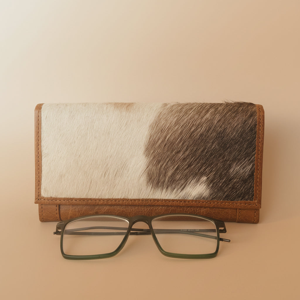 Wallet with cowhide pattern and glasses on a white background