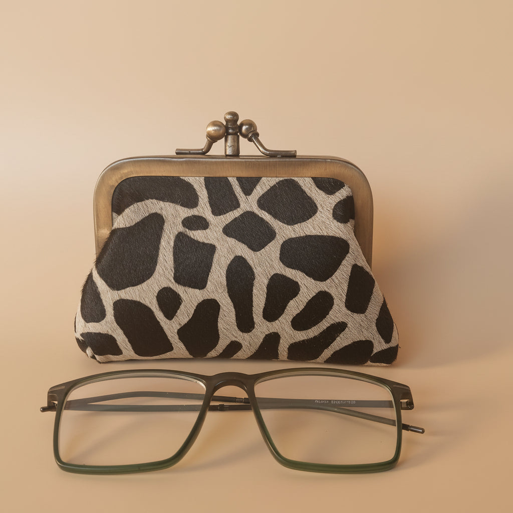 Giraffe-patterned case with a pair of glasses on a light gray background