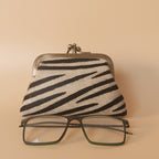 Zebra-striped case with a pair of glasses on a white background