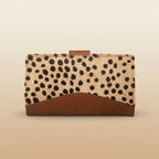 Cardholder with spotted pattern and brown leather accents on a light gray background