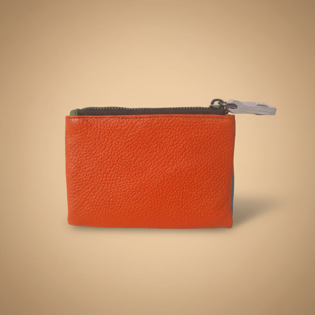 Orange leather zippered pouch on a light gray background