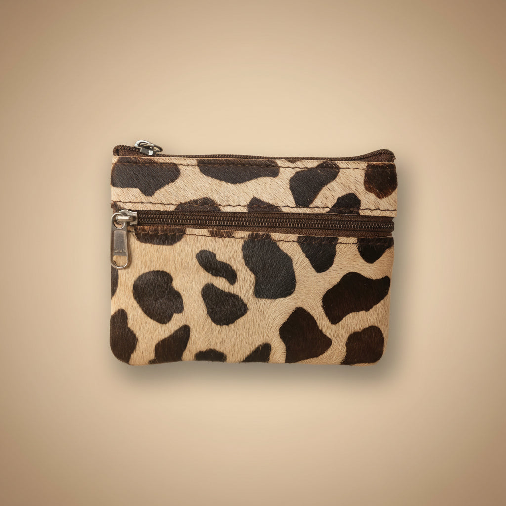 Small pouch with cow print pattern on a light gray background