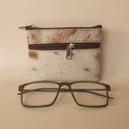 Eyeglasses next to a small pouch on a textured surface